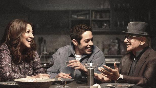 Plakat für die Fernsehserie „Bupkis“ mit Pete Davidson, Edie Falco und Joe Pesci am Esstisch.