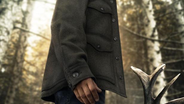 Ein Mann in Uniform und Hut steht vor einem Baum im Wald, im Vordergrund der Titel „Joe Pickett“.