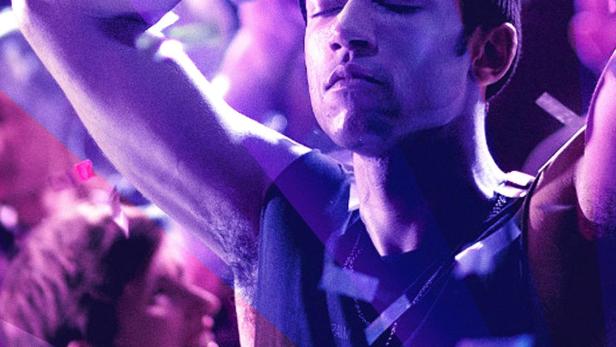 Ein Mann mit Mütze tanzt mit geschlossenen Augen auf einer Party, Konfetti fällt von der Decke.