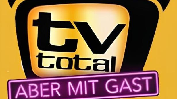 Das Logo der Fernsehsendung „TV total – Aber mit Gast“ auf gelbem Hintergrund.
