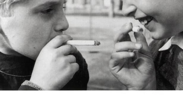 Zwei Jungen teilen sich eine Zigarette.