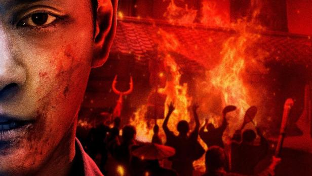 Das Filmplakat für „Gannibal“ zeigt einen blutverschmierten Mann vor einem brennenden Haus und einer Menschenmenge.