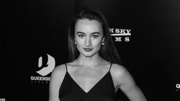 Schwarzweißporträt von Kelley Mack vor einem schwarzen Hintergrund mit Logos.