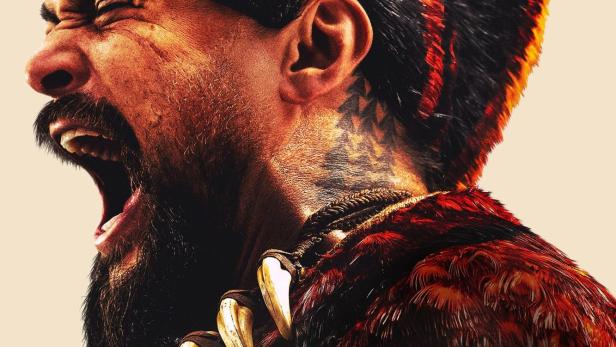 Ein schreiender Mann mit Kriegsbemalung und einem Halsband aus Zähnen, im Hintergrund der Schriftzug „Chief of War“.
