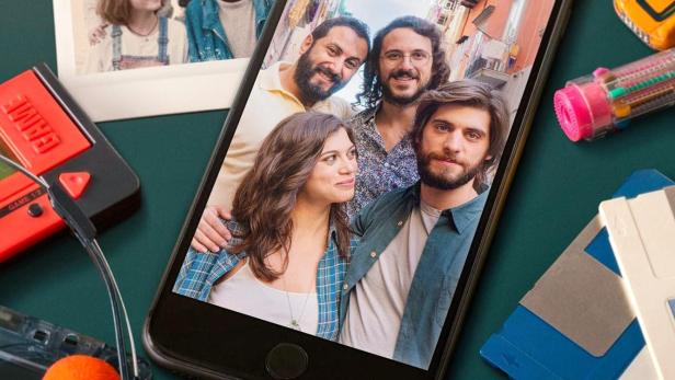 Das Poster für „Generazione 56K“ zeigt ein Smartphone mit einem Gruppenfoto, umgeben von Retro-Technologie.