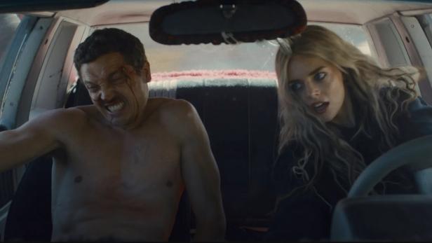 Ein Mann mit blutendem Gesicht und eine Frau sitzen in einem Auto.