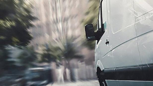 Ein weißer Lieferwagen fährt schnell eine Straße entlang, im Hintergrund Gebäude und der Titel „800 Metros“.