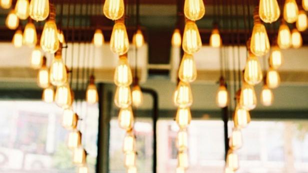 Eine Decke mit vielen hängenden Glühbirnen, die eine warme und einladende Atmosphäre schaffen.