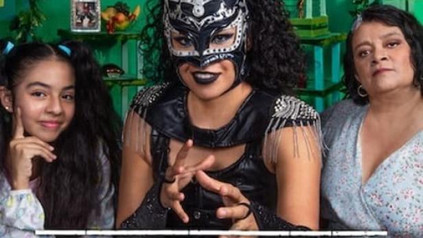 Eine Luchadora mit Maske posiert mit einem Mädchen und einer älteren Frau für das Poster von „Contra las Cuerdas“.