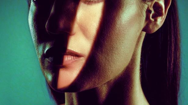 Das Poster für den Film „AKTRIS“ zeigt das Gesicht einer Frau im Schatten.