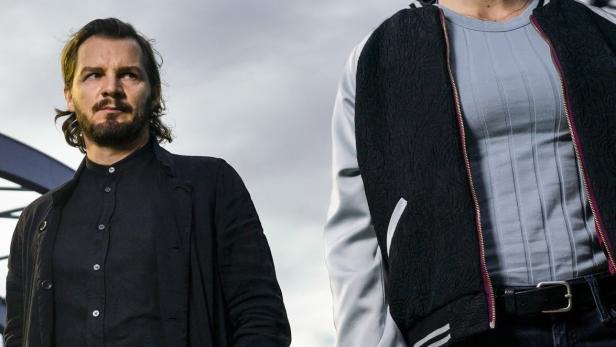 Ein Mann und eine Frau stehen vor einem grauen Himmel, im Vordergrund der Titel „Schneller als die Angst“.