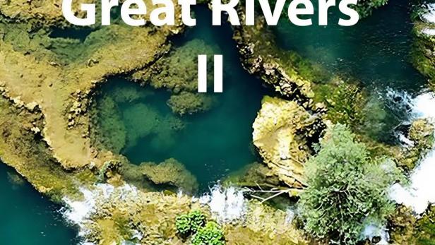 Eine Luftaufnahme von einem Fluss mit kleinen Wasserfällen und üppiger Vegetation.