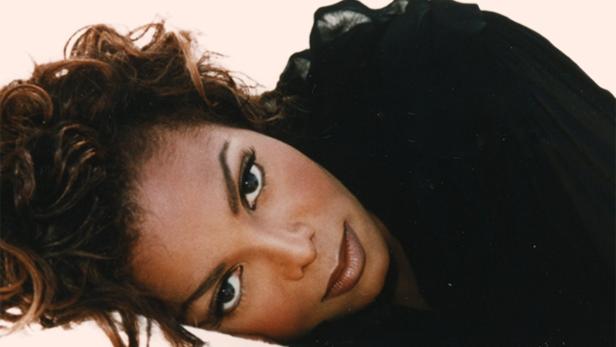 Ein Porträt der Sängerin Janet Jackson, die auf einem hellen Untergrund liegt.