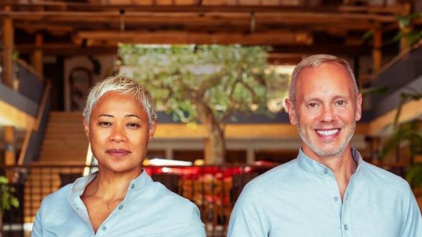 Zwei Angestellte präsentieren Speisen und Getränke in einem luxuriösen Hotel.