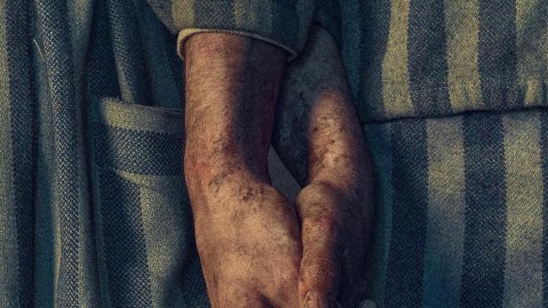 Das Buchcover von „Der Tätowierer von Auschwitz“ zeigt zwei Hände in gestreifter Häftlingskleidung.