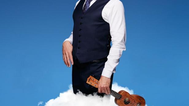 Dany de Boon steht auf einer Wolke und hält eine Ukulele.