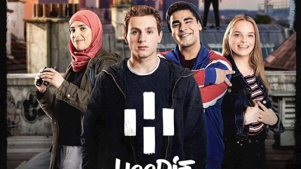 Das Filmplakat für „Hoodie“ zeigt vier Jugendliche auf einem Dach mit einem maskierten Mann im Hintergrund.