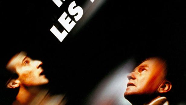 Das Filmplakat für „Regarde les hommes tomber“ zeigt zwei Männer, die nach oben schauen.