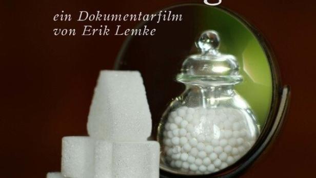 Das Filmplakat für den Dokumentarfilm „Homöopathie unwiderlegt?“ von Erik Lemke mit Zuckerwürfeln und Globuli.