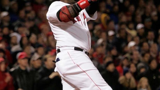 Ein Baseballspieler der Boston Red Sox beim Schlag vor einer Zuschauermenge.