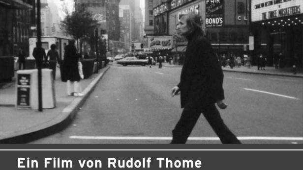 Rudolf Thome überquert eine Straße in New York, im Hintergrund Kinoplakate.