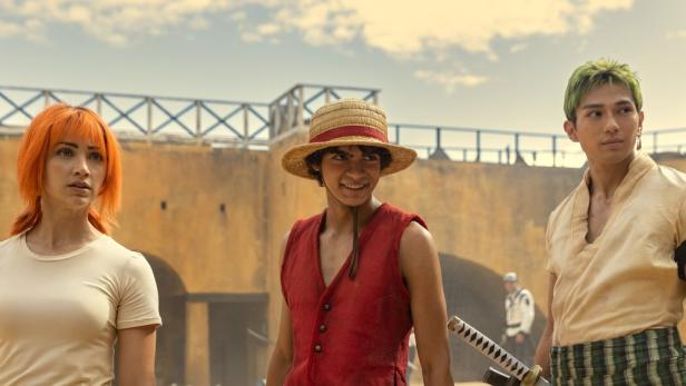 Die Besetzung der Netflix-Serie „One Piece“ steht vor einer Festung.