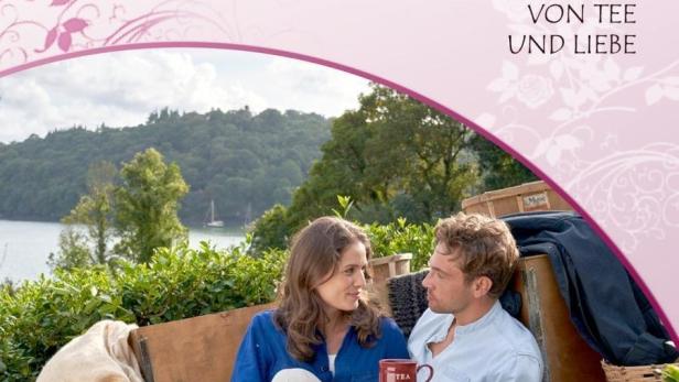 Ein Paar sitzt auf einer Decke mit Tassen und dem Titel „Rosamunde Pilcher – Von Tee und Liebe“.