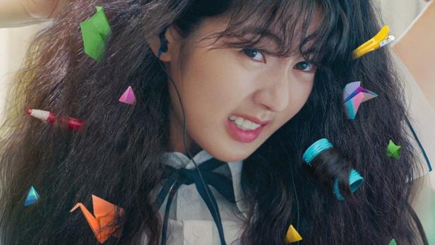 Eine junge Frau mit Lockenwicklern und Origami im Haar, Poster für den Netflix-Film „Geschichte einer Beichte“.