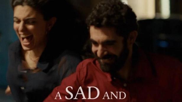 Ein Mann und eine Frau lachen auf dem Filmplakat zu „A Sad and Beautiful World“.