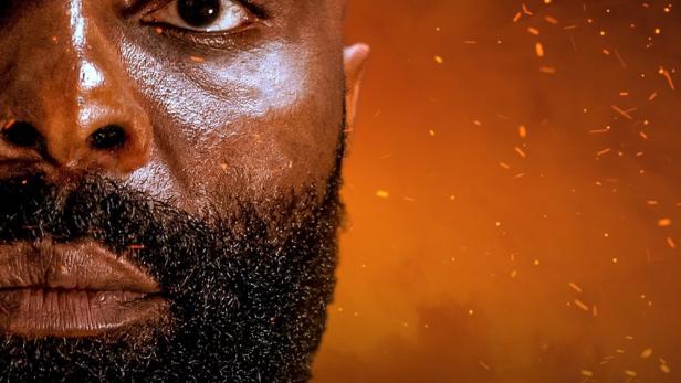 Das Filmplakat für „Le Roi des Ombres“ zeigt das Gesicht eines Mannes vor einem orangefarbenen Hintergrund.