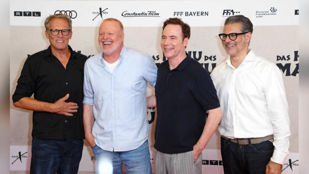 Vier Männer posieren auf dem roten Teppich für „Das Haus der Magie“.