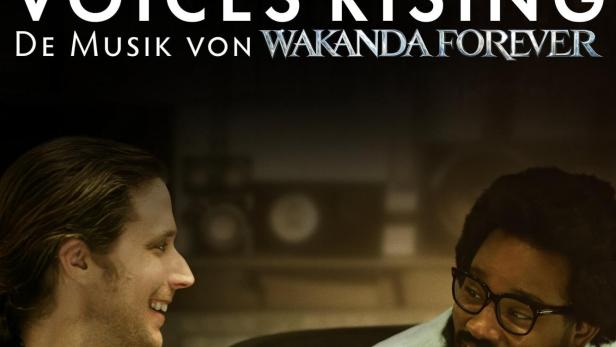 Zwei Männer sitzen vor dem Plakat für „Voices Rising: Die Musik von Wakanda Forever“.