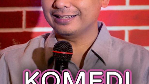 Ein Mann lächelt vor einem Mikrofon und dem Schriftzug „Komedi Kacau“.