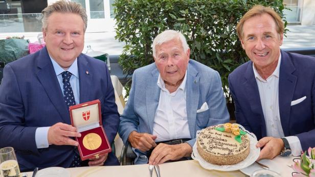Michael Ludwig, Peter Weck und Plachutta feiern einen Geburtstag mit Torte und Medaille.