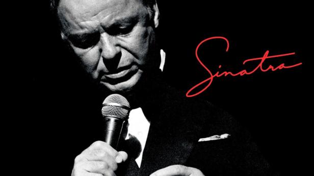 Frank Sinatra singt mit einem Mikrofon und hält eine Zigarre in der Hand.