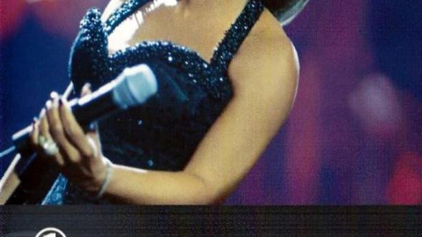 Donna Summer singt während eines Konzerts in einem glitzernden Kleid.