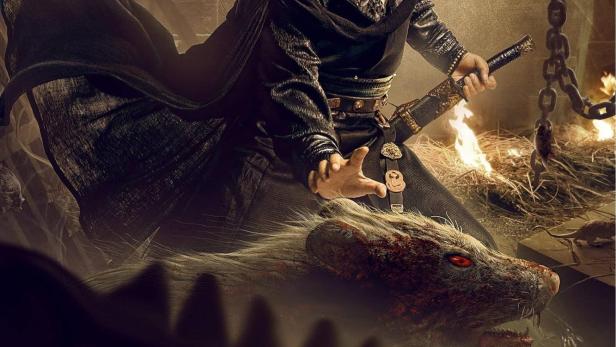 Ein Mann in traditioneller chinesischer Kleidung mit einem Schwert, im Hintergrund das Filmplakat „Detective Dee und das Geheimnis des Rattenfluches“.