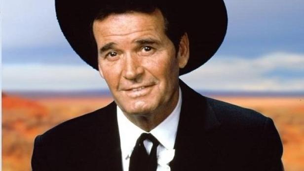 Ein Mann im Cowboyhut und Anzug vor einer Wüstenlandschaft, bewirbt die Serie „Bret Maverick“.