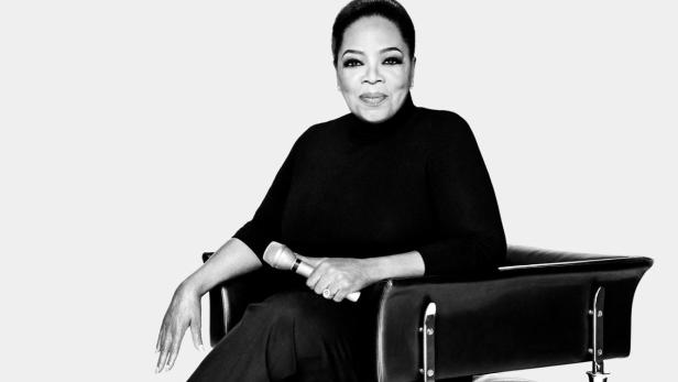 Oprah Winfrey sitzt in einem Sessel und hält ein Mikrofon in der Hand.