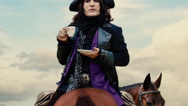 Ein Mann in historischer Kleidung sitzt auf einem Pferd und hält eine Teetasse.