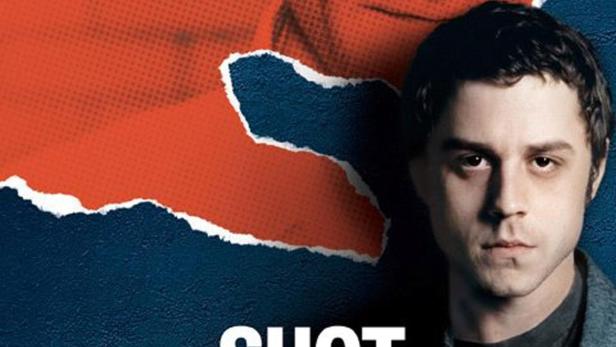 Das Filmplakat für „Shot in the Heart“ zeigt zwei Männer vor einem zerrissenen Hintergrund.