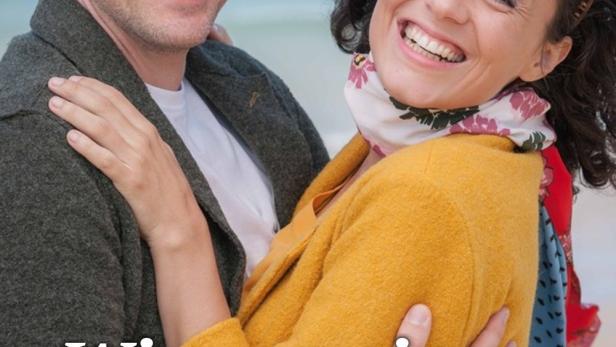 Ein lächelndes Paar umarmt sich am Strand; Filmposter „Wie von einem anderen Stern“.