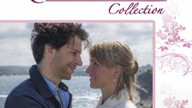 Ein Paar umarmt sich verliebt vor einer Küstenlandschaft; Titelbild von „Geerbtes Glück“ aus der Rosamunde Pilcher Collection.