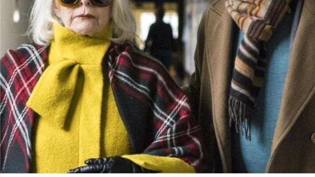 Eine ältere Frau mit Sonnenbrille und ein Mann stehen nebeneinander.