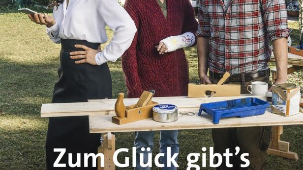 Drei Personen stehen an einem Tisch mit Werkzeugen im Garten.