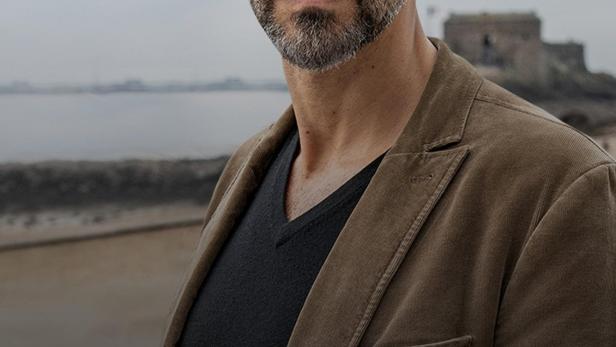 Kommissar Dupin vor bretonischer Küstenlandschaft.