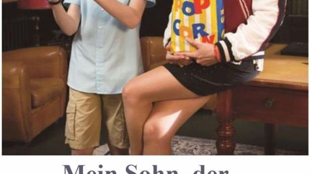 Ein Junge mit einem Atommodell und eine Frau mit Popcorn in der Komödie „Mein Sohn, der Klugscheißer“.