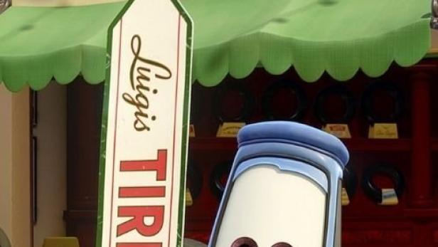 Ein blauer Auto-Charakter steht vor „Luigi's Tires“ aus dem Film „Cars“.