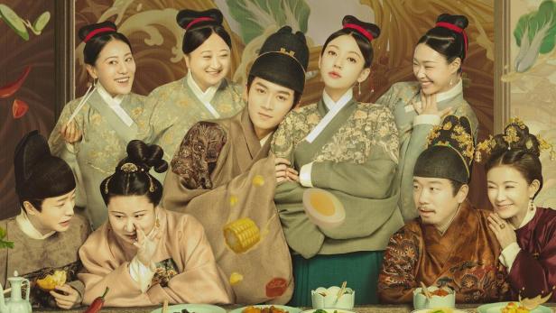 Das Filmplakat für „Delicacies Destiny“ zeigt eine Gruppe von Personen, die um einen Tisch mit Speisen sitzen.