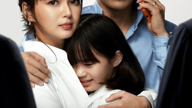 Ein Familienporträt mit einem besorgten Vater am Telefon, einer Mutter und einer Tochter.